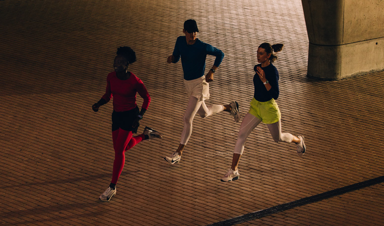 Three people running together, all wearing Apple Watch