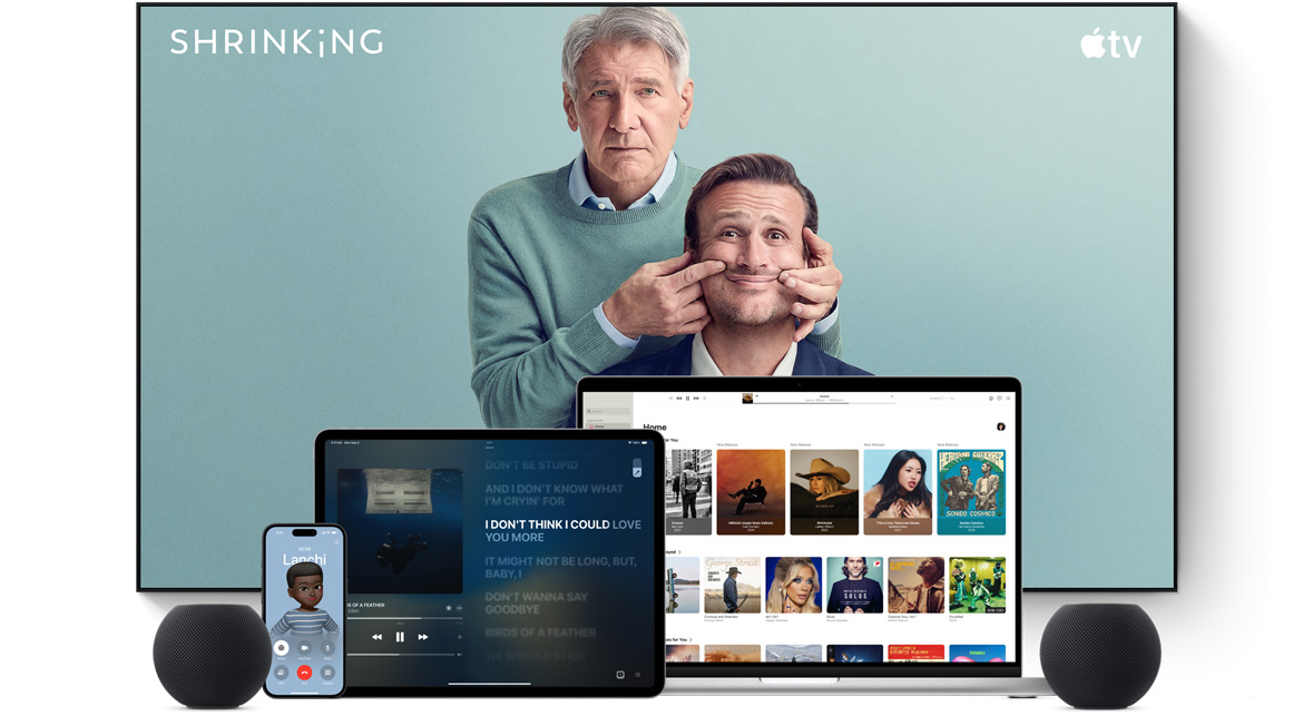 Large flat screen television showing two male characters from the Apple TV+ series shrinking. A MacBook Pro, an iPad, an iPhone, and a Midnight HomePod mini are arranged in front.