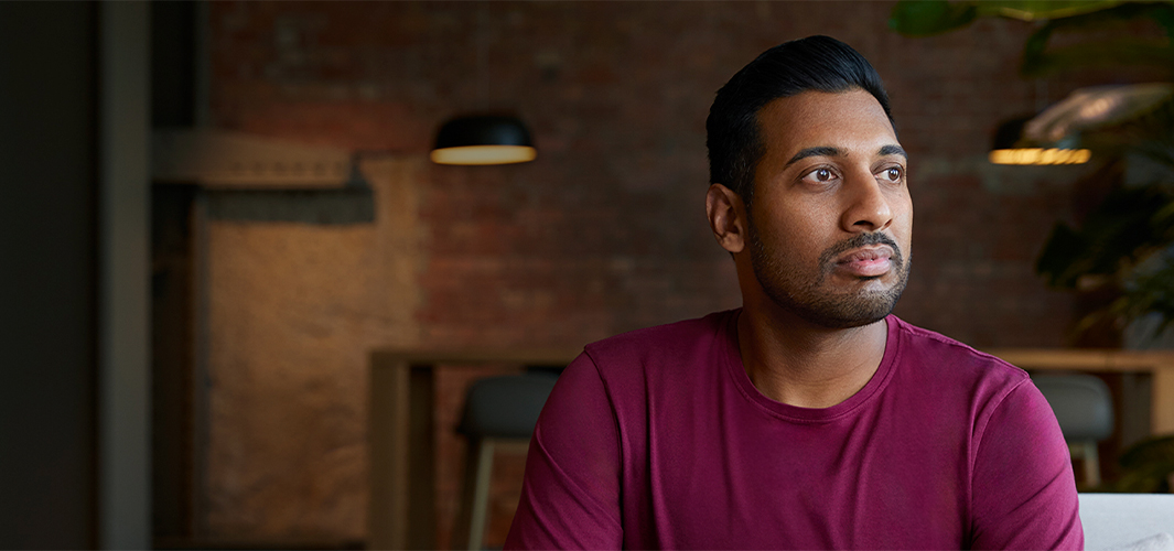 Amar 坐在室內，望向左邊。