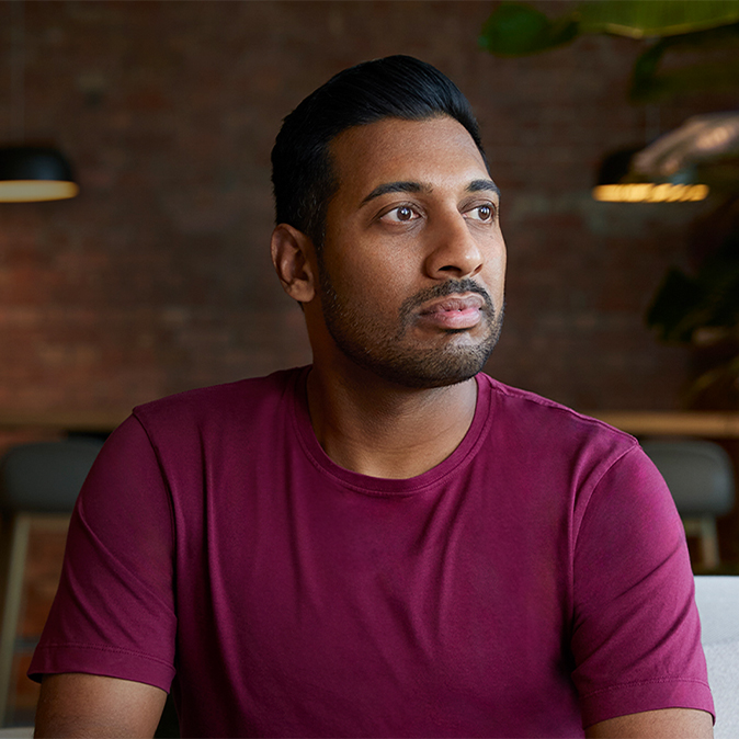 Amar 坐在室內，望向左邊。