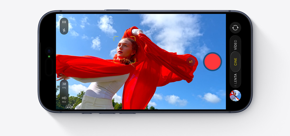 Pantalla de un iPhone en modo Cine que graba a una persona que baila al aire libre con un chal rojo que ondea al viento