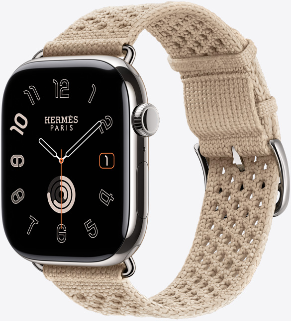 Apple Watch Hermès Series 11, titanium case, silver color, polished finish, edge-to-edge display, rounded corners, right side exterior, Digital Crown, microphone, side button, analog watch face (hour, minute, second hands), paired with Néo Tricot band, argile color (beige), knit polyamide yarn material, adjustment holes centered, silver color buckle and hardware