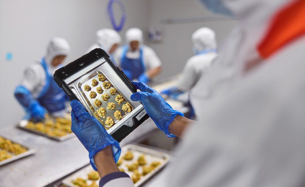 Un membre du personnel assure le contrôle de la qualité sur iPad.