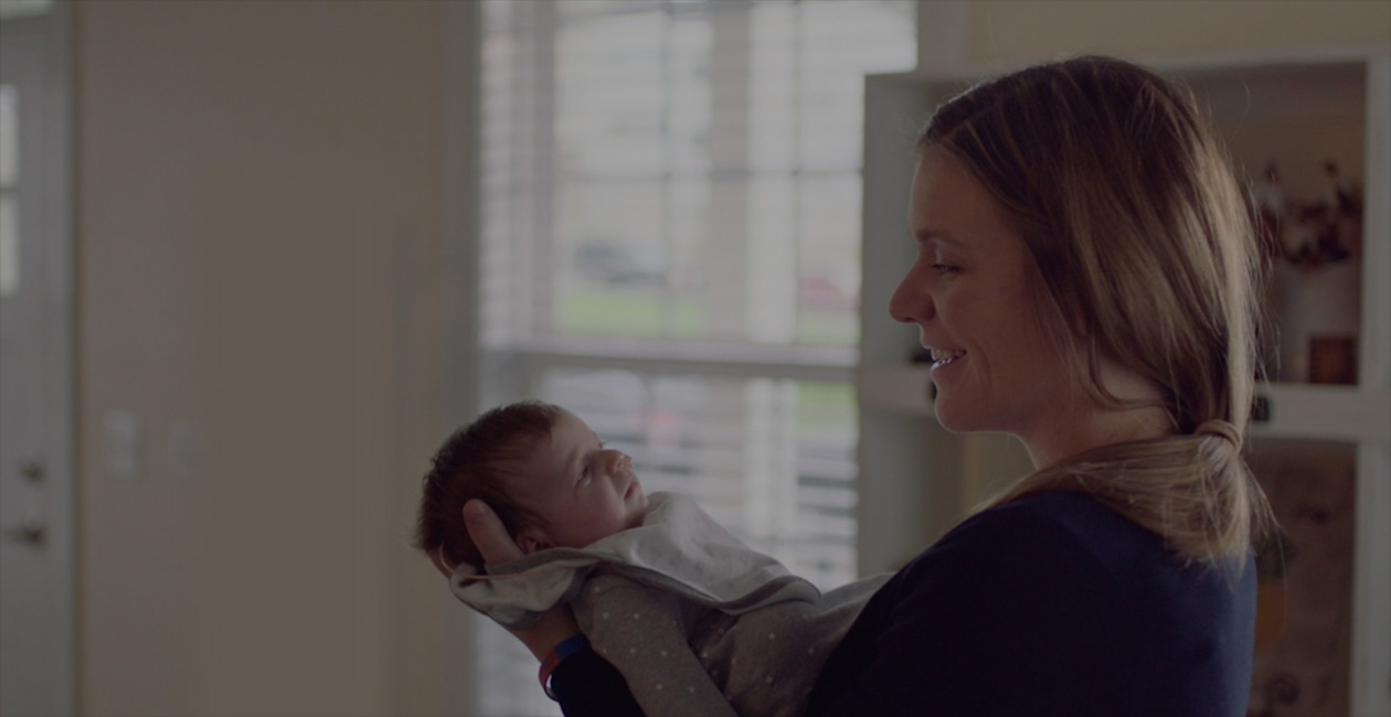 一位母親對這她的新生兒微笑。