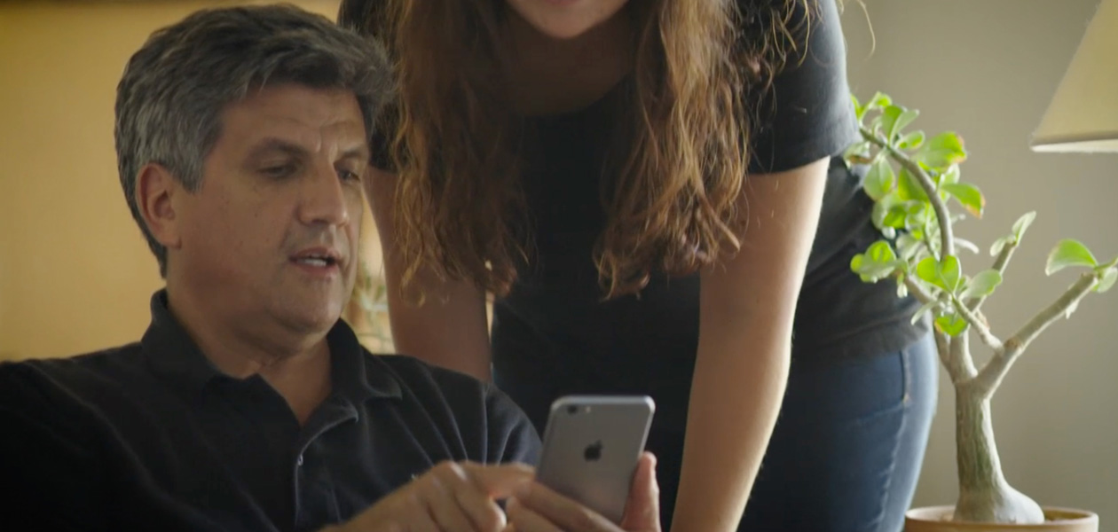 一位男士向另一位男士展示 iPhone 上的內容。