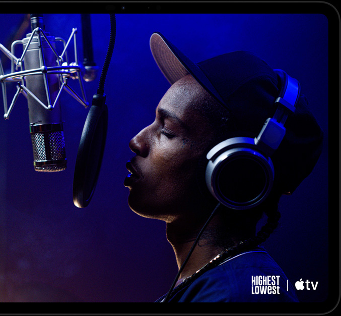 جهاز iPad Pro، الوضع الأفقي، الجزء الأمامي الخارجي، لون أسود فلكي، زوايا مدورة، إطار شاشة أسود، شاشة تُظهر +Apple TV يعرض مشهداً من فيلم Highest 2 Lowest من أعمال +Apple TV الأصلية مع الفنان ASAP Rocky بدور Yung Felon يغني الراب أمام ميكروفون