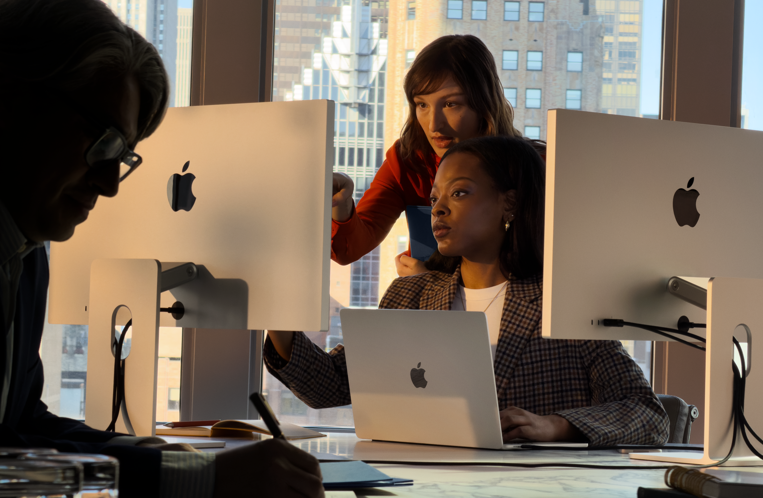 شخصان يستخدمان جهاز Mac في بيئة عمل