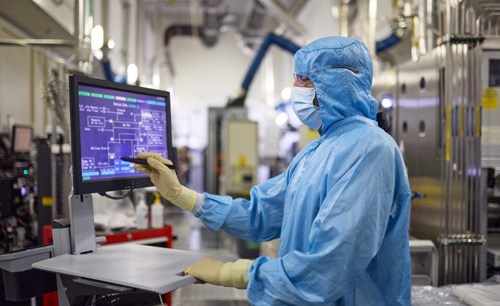A manfacturing employee uses a device to inspect production components