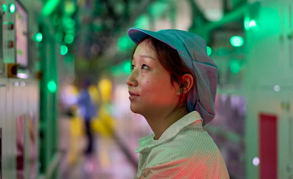 Een medewerker in uniform in een fabriek voor de fabricage van componenten